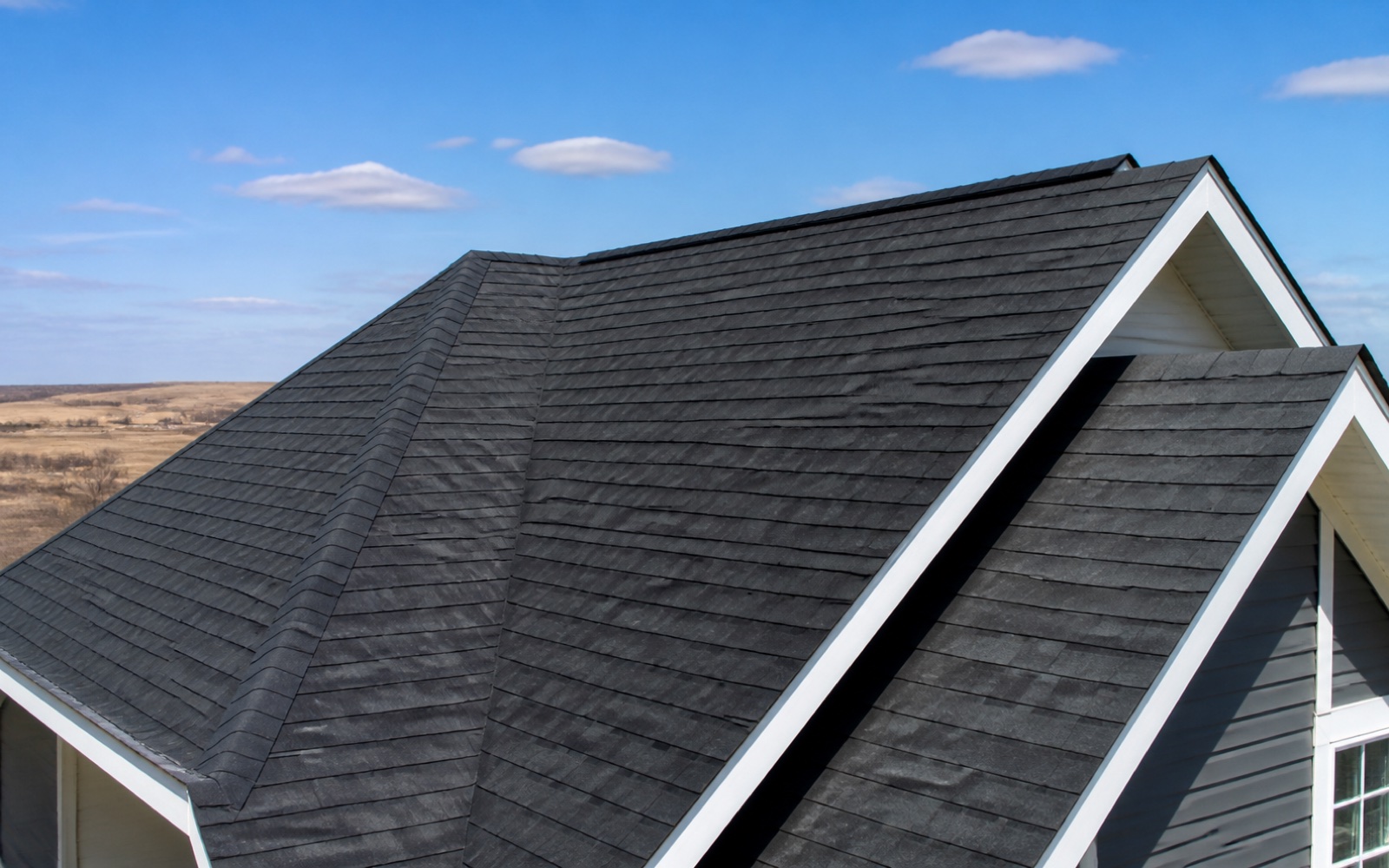 Finished charcoal architectural shingles with clean ridge caps and valley lines